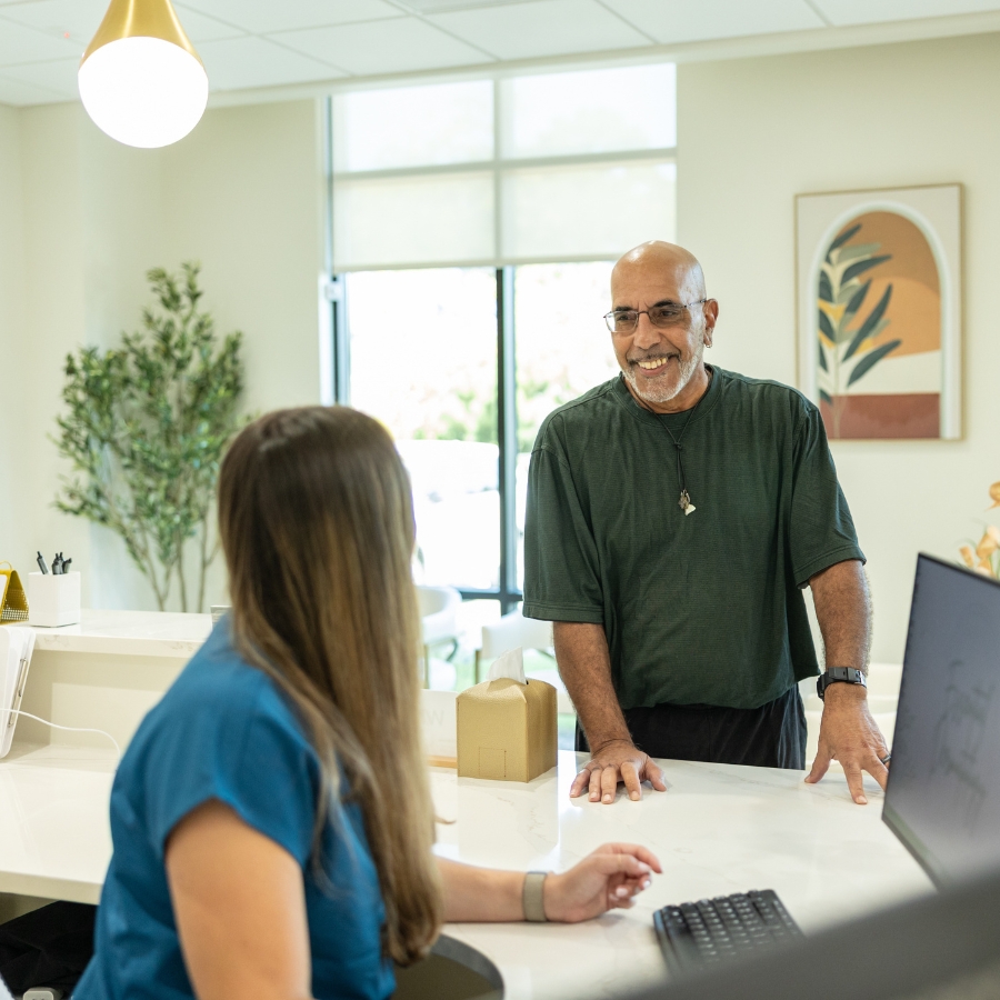 receptionist greets patient at health care clinic